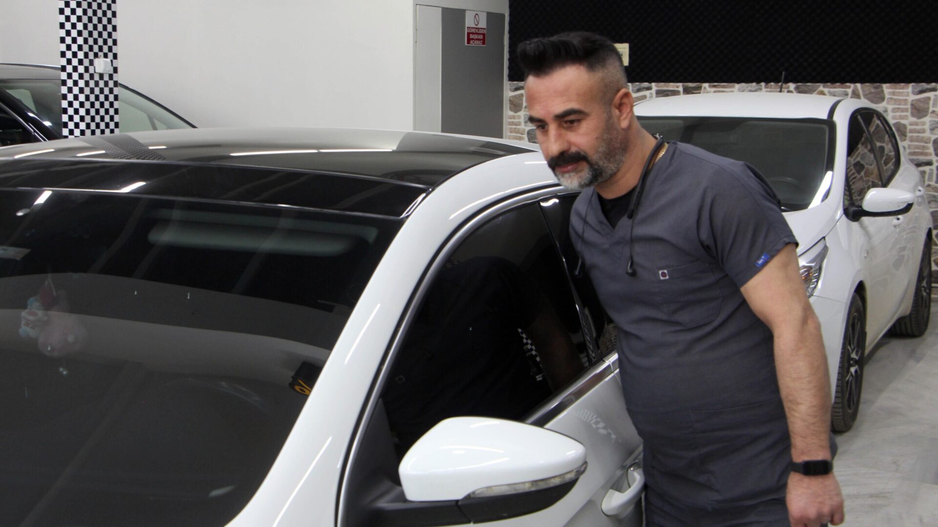 Kaporta ustası, araçları doktor kıyafeti giyerek tamir ediyor Kaporta ustası, araçları doktor kıyafeti giyerek tamir ediyor