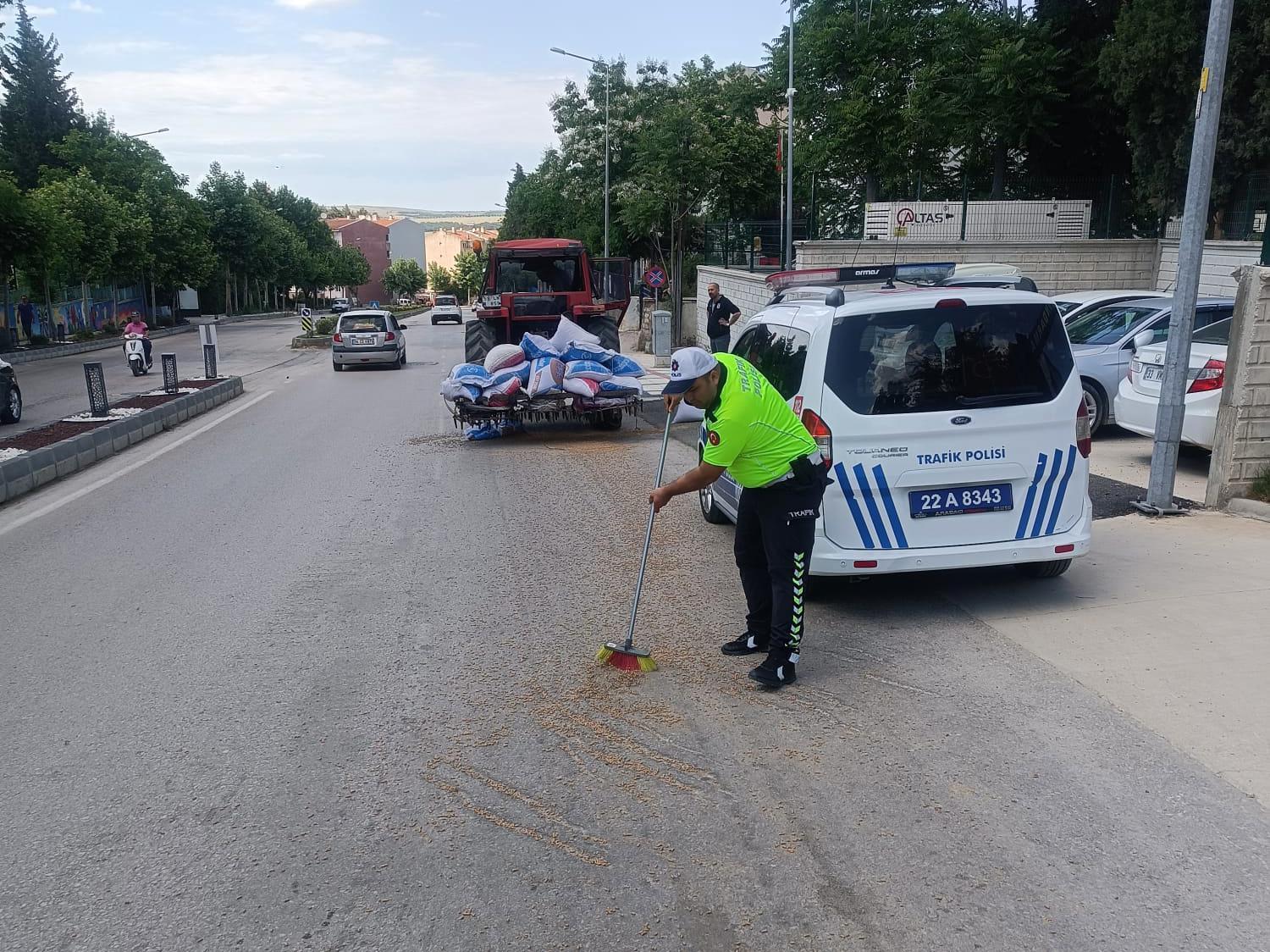 Polis, traktörden düşerek yola saçılan kuzu yemlerini topladı Polis, traktörden düşerek yola saçılan kuzu yemlerini topladı